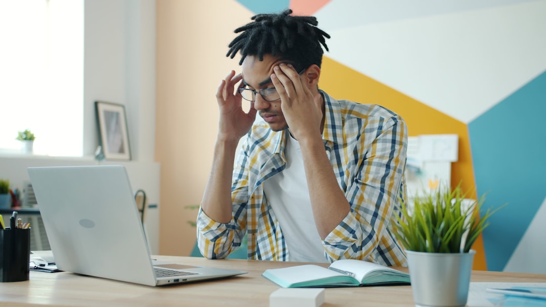Business owner reviewing website analytics on a laptop with warning icons for slow speed, mobile issues, and low conversions beside a contact form dashboard